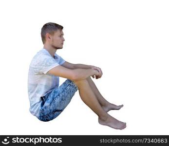 Side view full length portrait of a casual young man sitting on the ground and meditate isolated over white background.