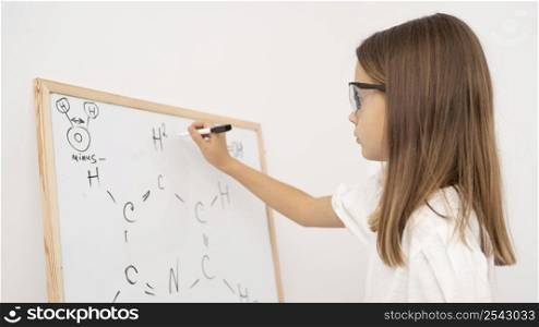side view girl learning science with whiteboard