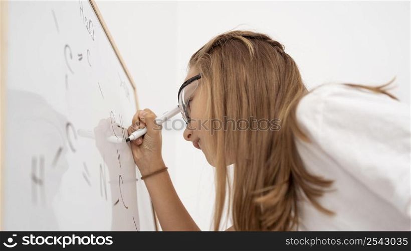side view girl writing whiteboard while learning science