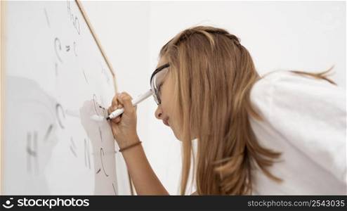 side view girl writing whiteboard while learning science