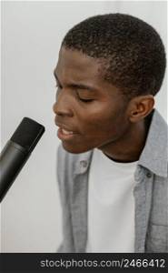 side view handsome male musician singing with microphone