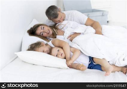 side view happy family laying bed