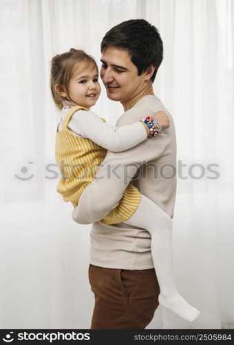 side view happy father holding his daughter