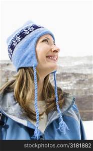Side view head and shoulder of attractive smiling mid adult Caucasian blond woman wearing blue ski clothing.