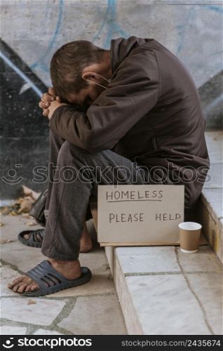 side view homeless man stairs with cup help sign