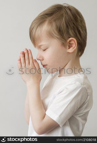 side view little boy praying