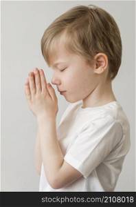 side view little boy praying