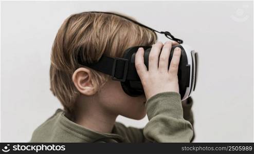side view little boy using virtual reality headset