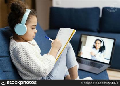 side view little girl during online school with laptop headphones