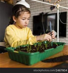 side view little girl measuring sprouts growing home