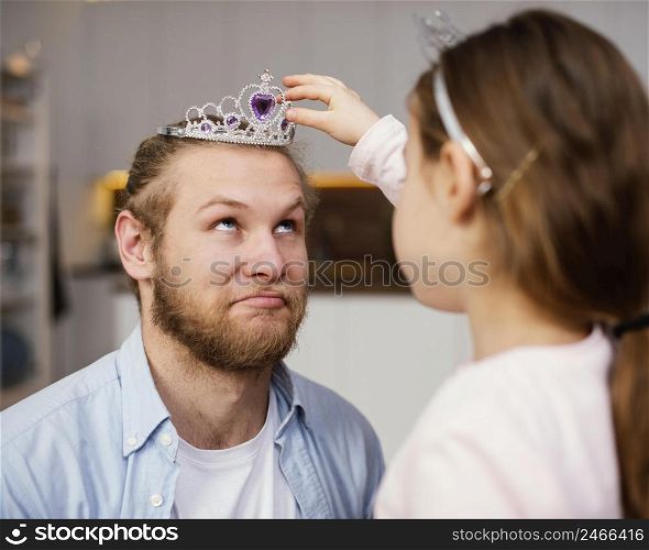 side view little girl placing tiara father s head