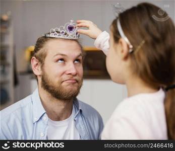side view little girl placing tiara father s head