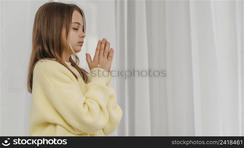 side view little girl praying with copy space