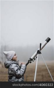 side view little girl using telescope