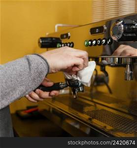 side view male barista cleaning professional coffee machine