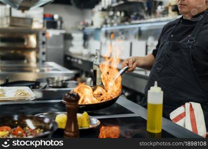 side view male chef flambeing dish. Resolution and high quality beautiful photo. side view male chef flambeing dish. High quality beautiful photo concept