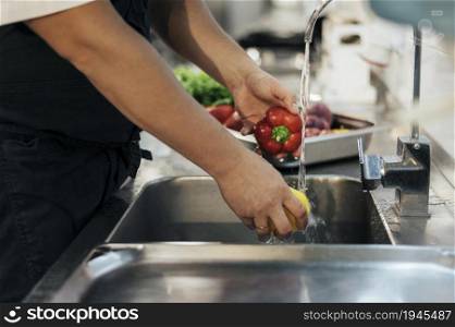 side view male chef washing vegetables. High resolution photo. side view male chef washing vegetables. High quality photo