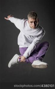 side view male dancer purple jeans posing mid air