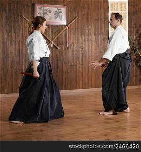 side view male martial arts instructor female trainee practice hall