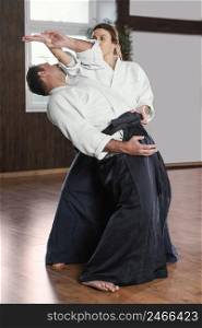 side view male martial arts instructor training practice hall with female trainee