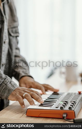 side view male musician home playing electric keyboard 2