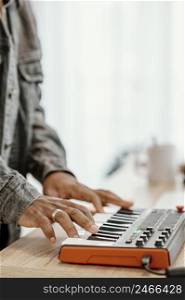 side view male musician home playing electric keyboard 2