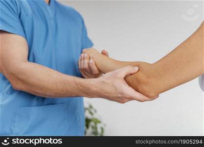 side view male osteopathic therapist checking female patient s elbow joint movement. Beautiful photo. side view male osteopathic therapist checking female patient s elbow joint movement