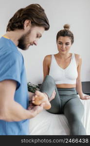 side view male osteopathic therapist checking female patient s leg movement