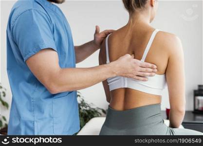 side view male osteopathic therapist checking female patient s scapula bone. High resolution photo. side view male osteopathic therapist checking female patient s scapula bone. High quality photo