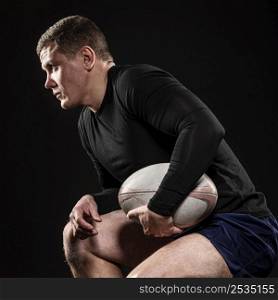 side view male rugby player holding ball