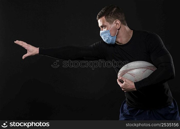 side view male rugby player with medical mask ball