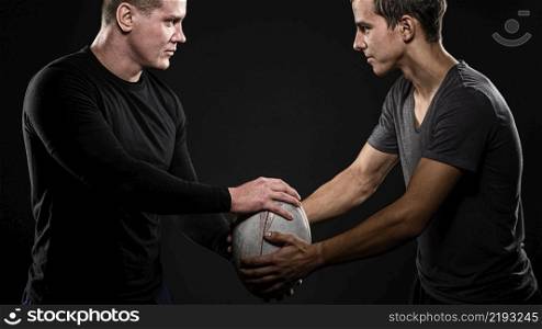 side view male rugby players holding ball