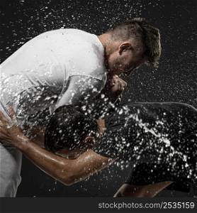 side view male rugby players with ball water splashes