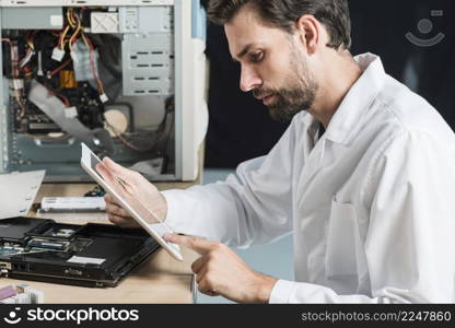 side view male technician using digital tablet