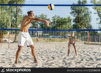 side view male volleyball player beach with woman playing
