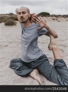 side view man beach exercising yoga