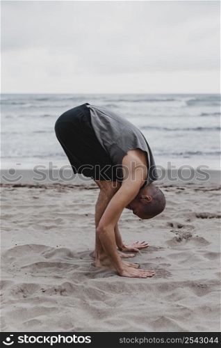side view man beach exercising yoga positions