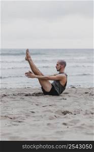 side view man beach yoga position with copy space