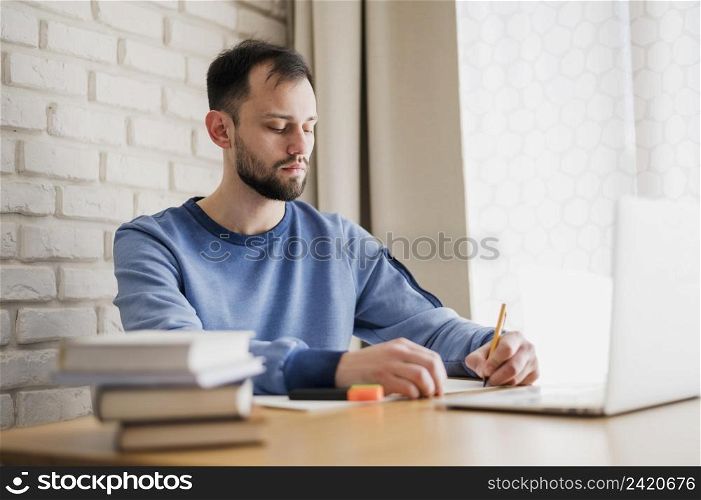 side view man desk being online tutored