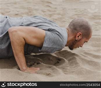side view man doing yoga sand