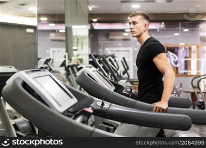 side view man gym treadmill