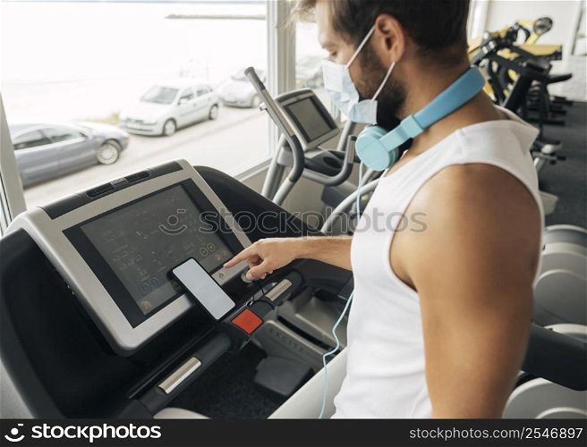 side view man gym using treadmill