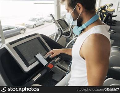 side view man gym using treadmill