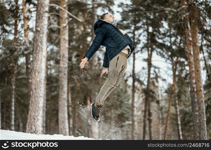 side view man jumping outdoors nature during winter