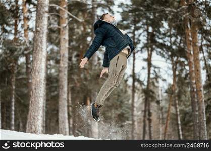side view man jumping outdoors nature during winter