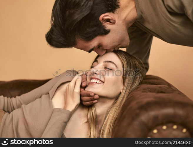 side view man kissing happy woman forehead