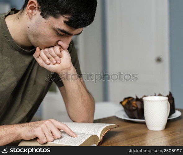 side view man kitchen reading from bible