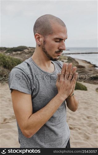 side view man meditating position outdoors