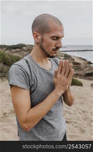 side view man meditating position outdoors