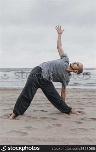 side view man practicing yoga positions outside